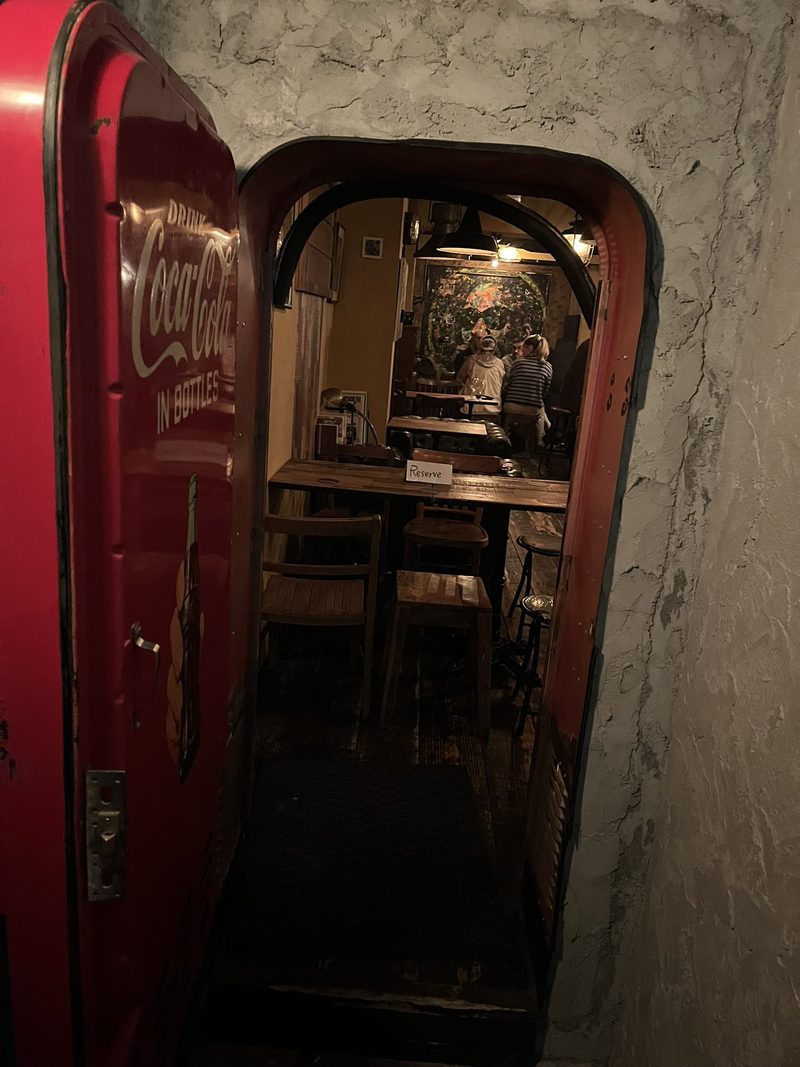Gasten in een café met een betonnen plafond en een wand vol langspeelplaten