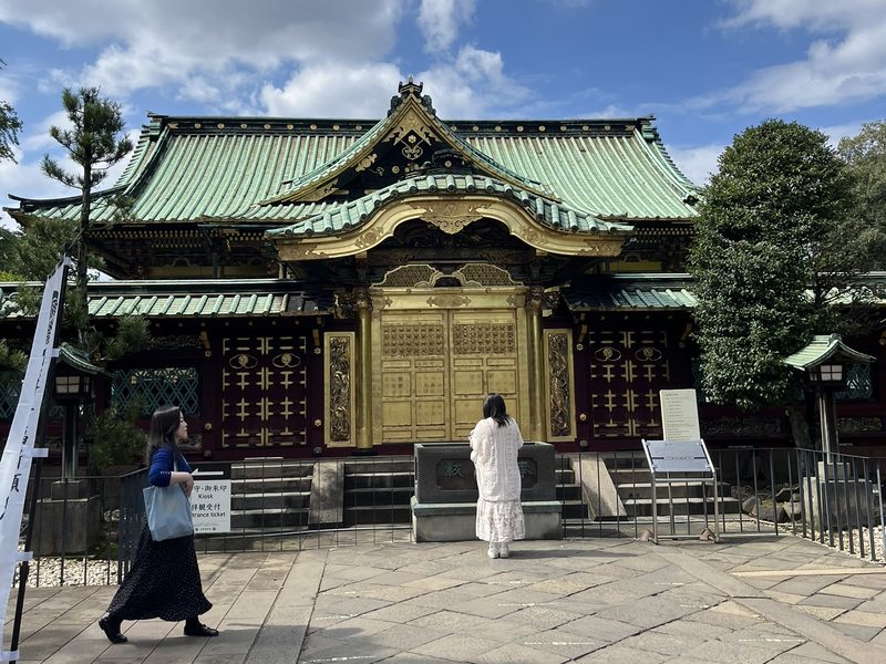 Een Japanse tempel met een groen dak en gouden deuren