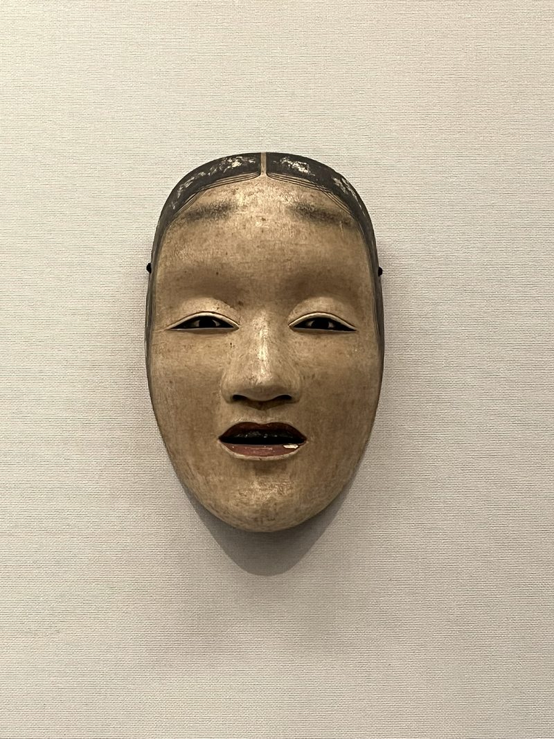 Nohmasker van een vrouw met een rustige uitdrukking en een licht geopende mond